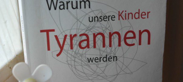 Das Bild zeigt ein Buch und eine Kunstpflanze